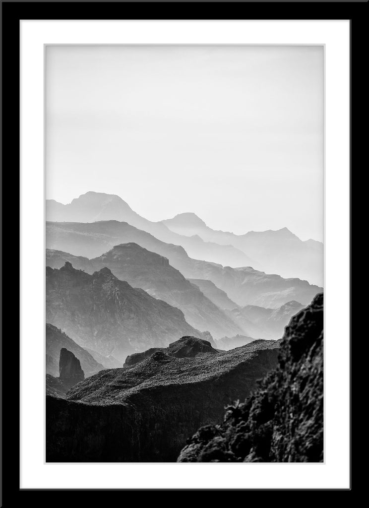 Schwarz-Weiß Natur Fotografie von Bergen, die im Nebel verschwinden. Fotokunst online kaufen. Wandbild im Rahmen