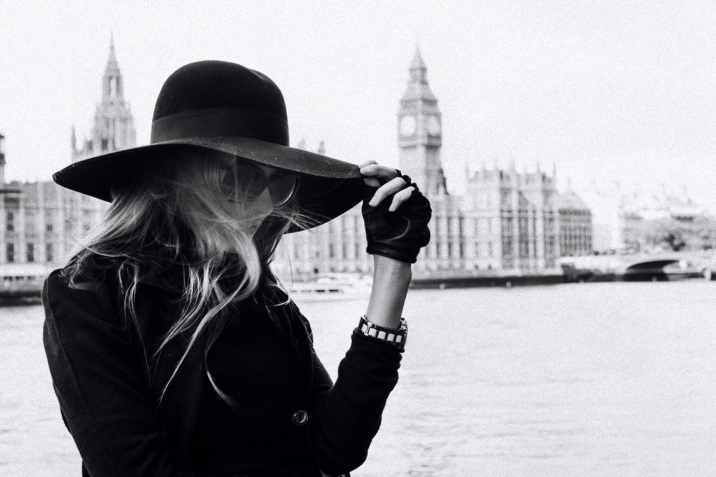 Schwarz-Weiß People Fotografie von einer Frau mit Hut in schwarz vor der Themse und dem Palace of Westminster. Fotokunst und Bilder online kaufen. Wandbild hinter Acrylglas oder als Poster