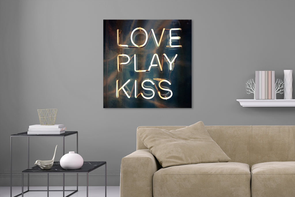 Aufgehängte Fotografie einer Typografie Leuchtreklame  mit den Worten Love Play Kiss. Fotokunst und Bilder online kaufen. Wandbild hinter Acrylglas oder als Poster