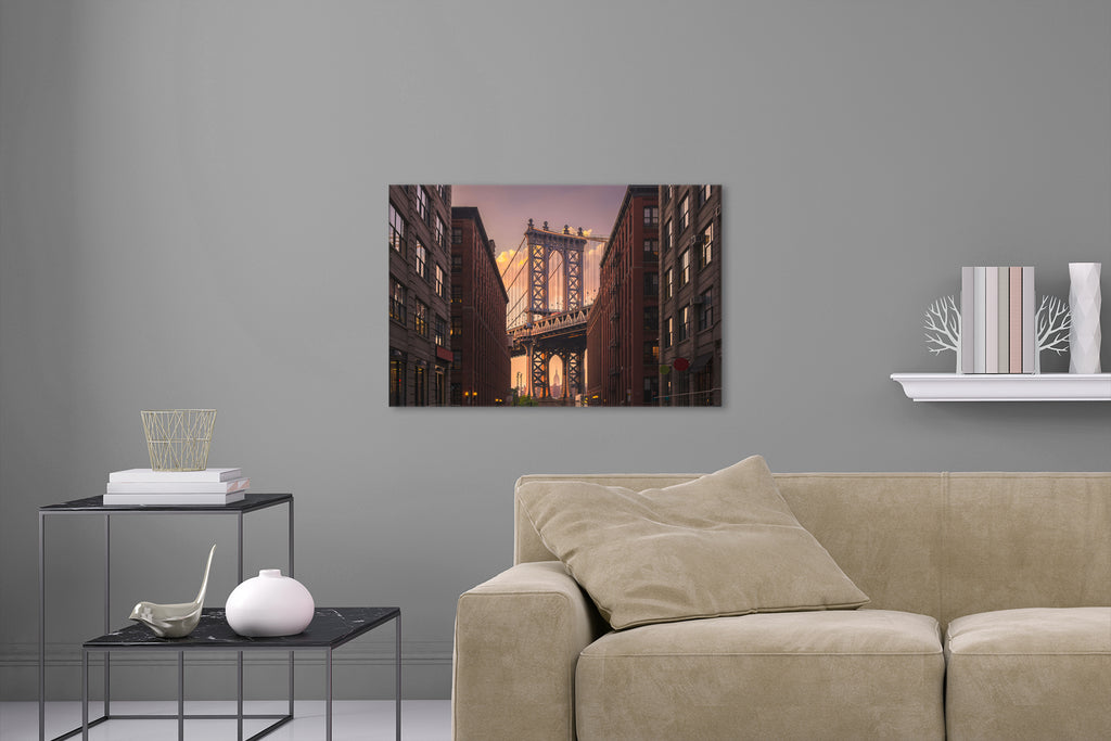 Aufgehängte Stadt Architektur Fotografie der Manhattan Bridge durch eine Häuserfront bei Sonnenuntergang in New York. Fotokunst und Bilder online kaufen. Wandbild hinter Acrylglas oder als Poster
