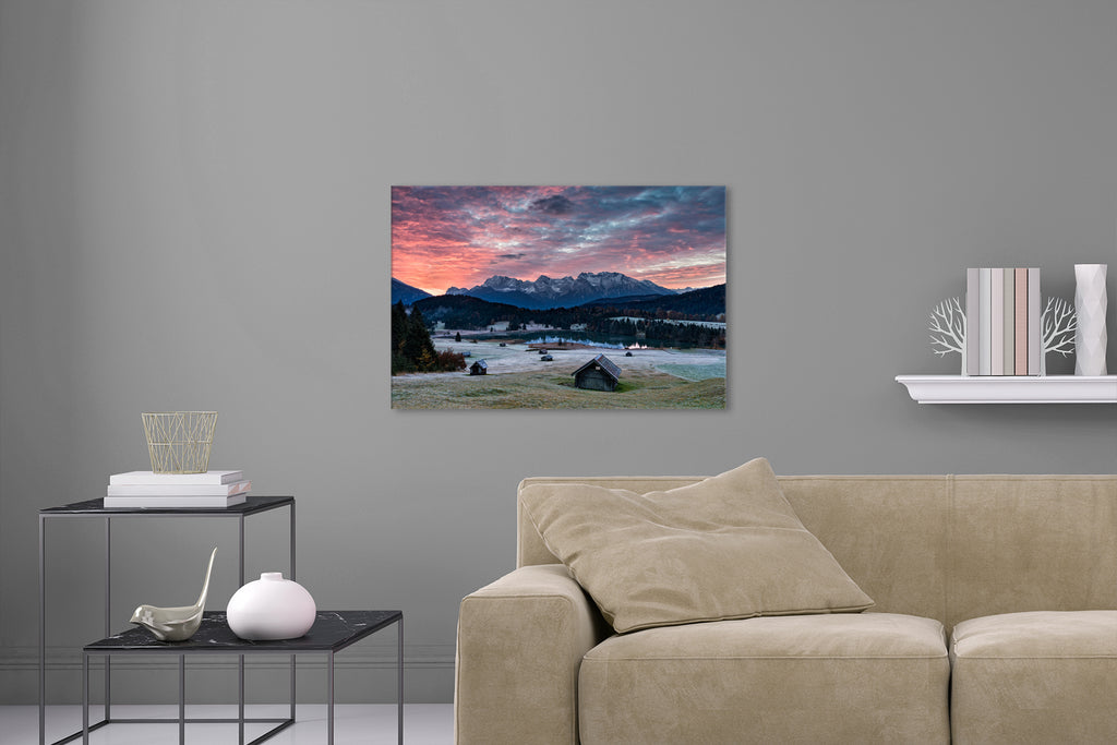 Aufgehängte Landschafts Natur Fotografie des Geroldsee bei Sonnenaufgang mit Holzhütten im Vordergrund und den Alpen. Fotokunst und Bilder online kaufen. Wandbild hinter Acrylglas oder als Poster