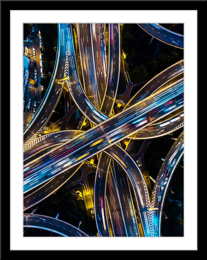 Architektur Fotografie von einer mehrspurigen Autobahn Brücken Kreuzung mit viel Verkehr bei Nacht im Hochformat. Fotokunst und Bilder online kaufen. Wandbild im Rahmen