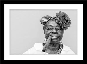 Schwarz-Weiß People Fotografie von einer dunkelhäutigen älteren Dame mit Blumen um Haar die eine decke Zigarre raucht. Fotokunst und Bilder online kaufen. Wandbild im Rahmen