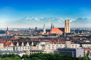 Architektur Fotografie der Stadt München mit der Frauenkirche und den Alpen. Fotokunst und Bilder online kaufen. Wandbild hinter Acrylglas oder als Poster