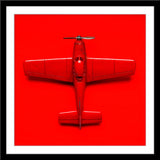 Stilllife Fotografie von einem roten Spielzeug Flugzeug auf rotem Hintergrund im quadratischen Format. Fotokunst und Bilder online kaufen. Wandbild im Rahmen