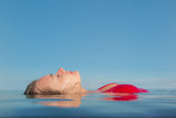 People Fotografie von einer auf dem Wasser liegenden Frau mir roten Bikini. Fotokunst und Bilder online kaufen. Wandbild hinter Acrylglas oder als Poster