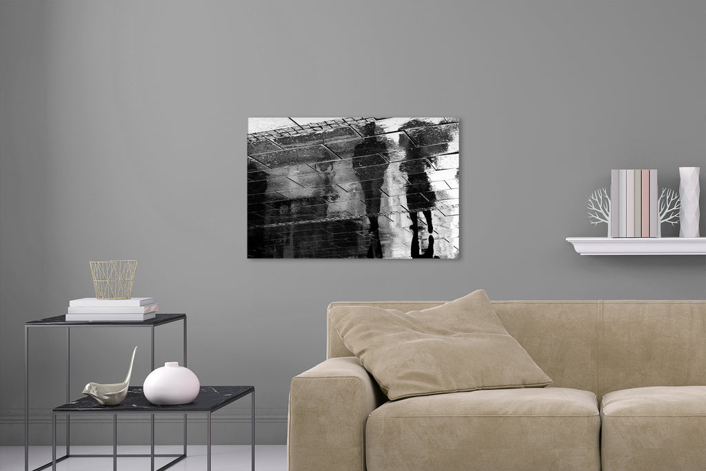 Aufgehängte Fotografie einer Reflexion von zwei Spaziergängern auf dem Gehsteig. Fotokunst und Bilder online kaufen. Wandbild hinter Acrylglas oder als Poster