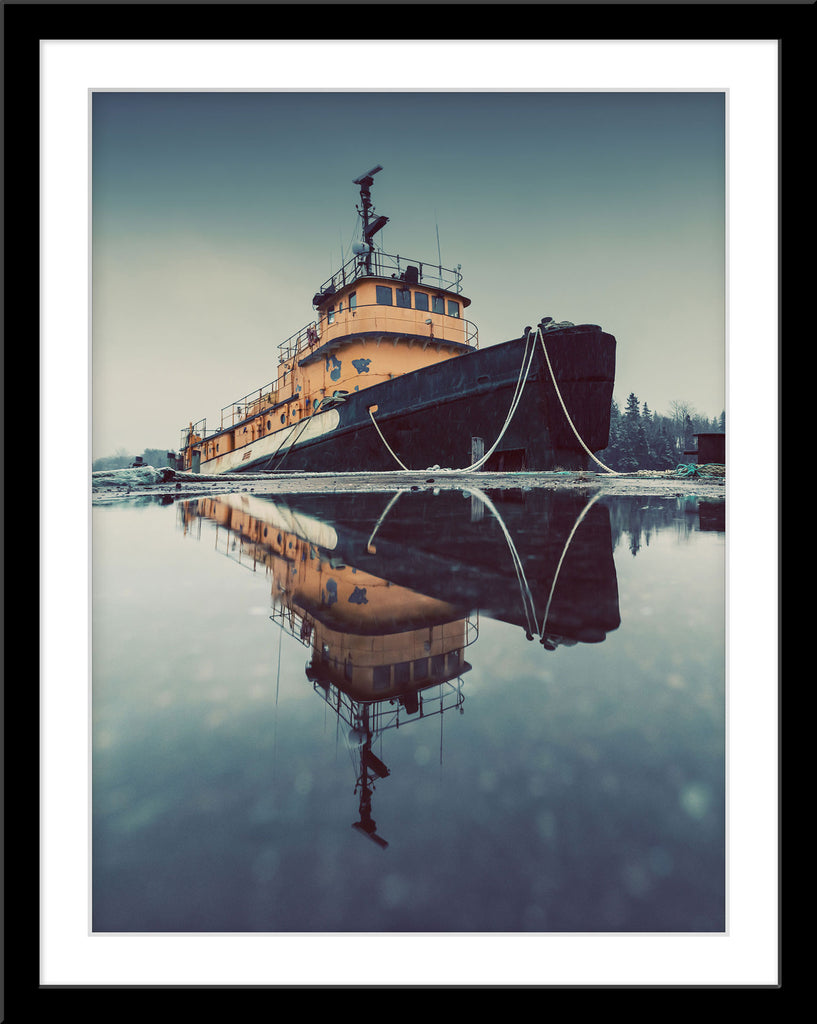 Fotografie von einem alten Schiff das sich in einer Pfütze spiegelt im Winter. Fotokunst und Bilder online kaufen. Wandbild im Rahmen