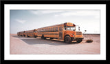 Fotografie von amerikanischen gelben Schulbussen die auf Schotter stehen im Panorama Format. Fotokunst und Bilder online kaufen. Wandbild im Rahmen