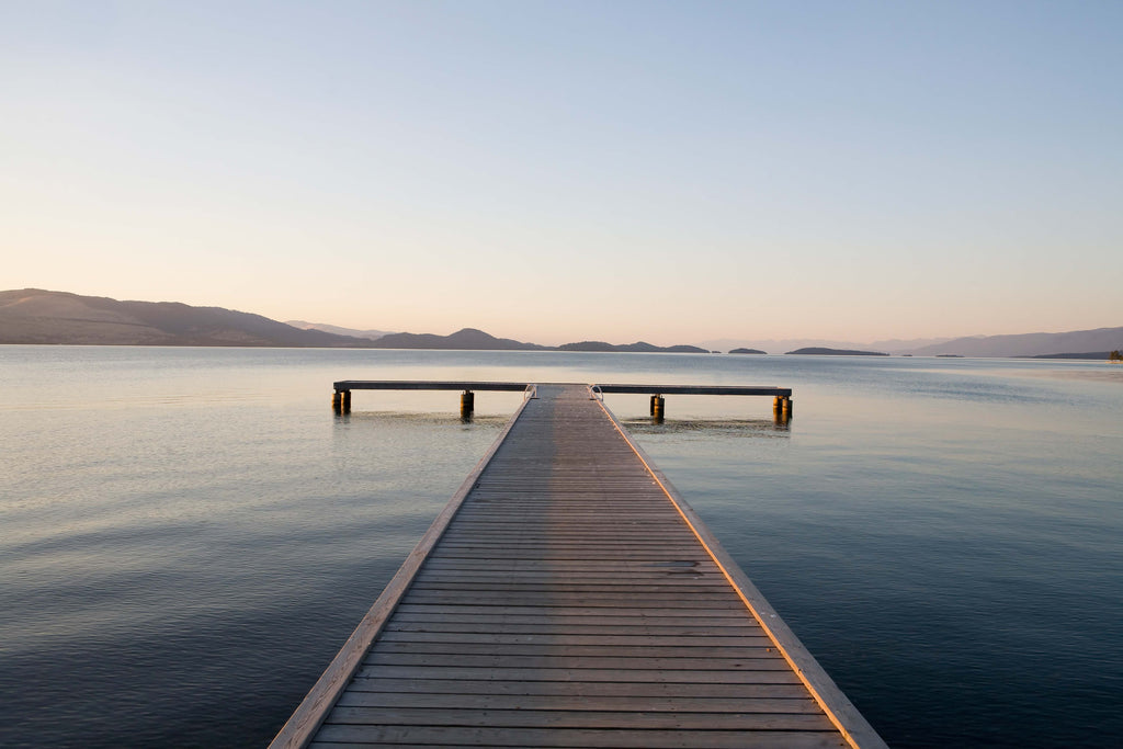 Landschafts Fotografie von einem Steg an einem ruhigen See bei Sonnenuntergang. Fotokunst und Bilder online kaufen. Wandbild hinter Acrylglas oder als Poster