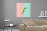 Aufgehängte Abstrakte Fotografie von einer in der Mitte geteilten Banane auf rosa und türkisen Hintergrund im quadratischen Format. Fotokunst und Bilder online kaufen. Wandbild hinter Acrylglas oder als Poster 