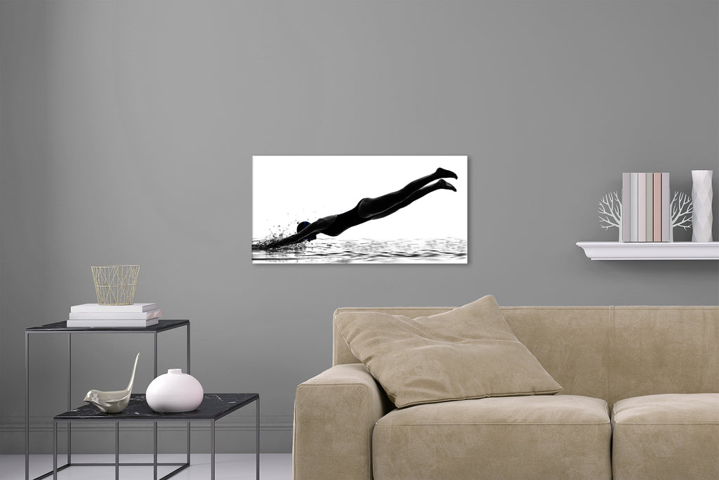 Aufgehängte Schwarz-Weiß People Fotografie von einer Schwimmerin die in Wasser eintaucht vor weißem Hintergrund. Fotokunst und Bilder online kaufen. Wandbild hinter Acrylglas oder als Poster