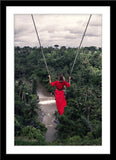 People Natur Fotografie von einer Frau in rotem Kleid auf einer Schaukel vor Dschungel im Hochformat. Fotokunst und Bilder online kaufen. Wandbild im Rahmen