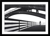 Schwarz-Weiß People Architektur Fotografie von einem Mann der unter einer Brücke steht im Querformat. Fotokunst und Bilder online kaufen. Wandbild hinter Acrylglas oder als Poster