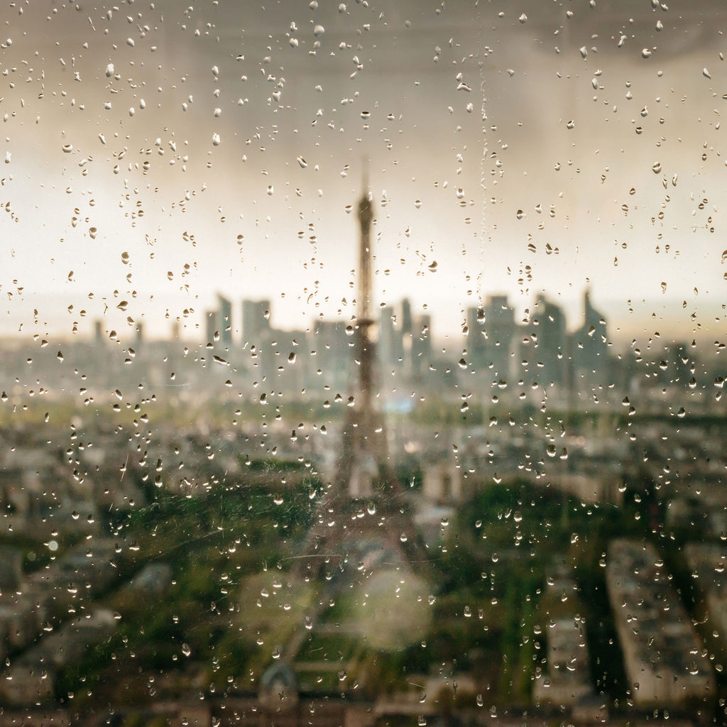 Architektur Fotografie vom Eiffel Turm durch ein verregnetes Fenster im quadratischen Format. Fotokunst und Bilder online kaufen. Wandbild hinter Acrylglas oder als Poster